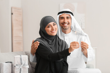 Young Muslim couple with sparklers at home