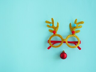 Carnival Christmas gold glasses with deer antlers and red Christmas ball. Deer silhouette, new year concept. Ploss layout.