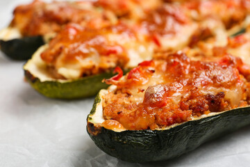 Meat stuffed zucchini boats on table, closeup