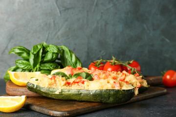 Wooden board with quinoa stuffed zucchini boats on dark background