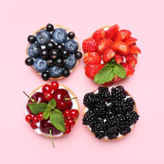 Tasty berry tartlets on pink background