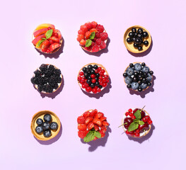 Tasty berry tartlets on purple background