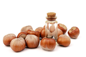 Hazelnut oil in glass bottle isolated on white background. Hazelnut background, healty food