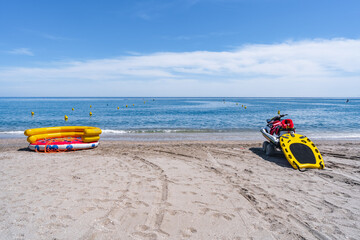 Fototapeta premium Calle delimitada por bollas sobre el agua del mar en la playa para la salida de vehículos de recreo y salvamento un día soleado con cielo azul. Desde playa Burriana, Nerja, Málaga, Andalucía, España.