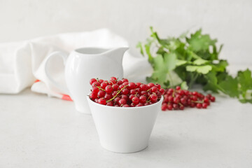 Bowl with ripe red currant on light background