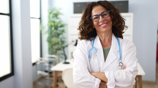 Middle age hispanic doctor woman with crossed arms