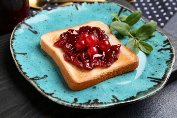 Plate with toast and tasty cranberry jam, closeup