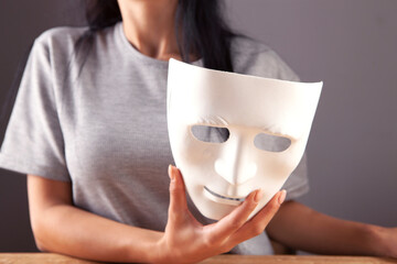  girl with holding a white theatrical mask