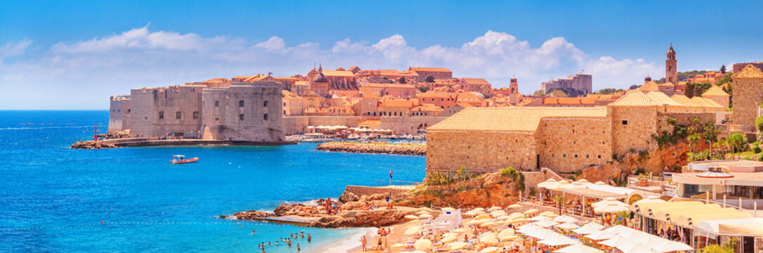 Coastal summer landscape, panorama - view of the city beach on the background of the Old Town of Dubrovnik on the Adriatic coast of Croatia © rustamank