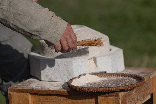 man cleans stone mill