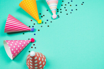 Obraz premium Colorful birthday caps on a blue background. Top view.