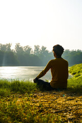 silhouette of a boy yoga in park - health concept