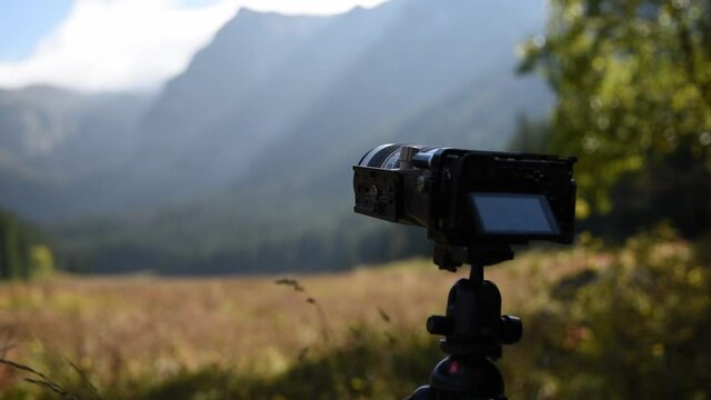 Professional camera shooting time lapse in the mountains. Blogger shooting national natural park using modern professional videography device.