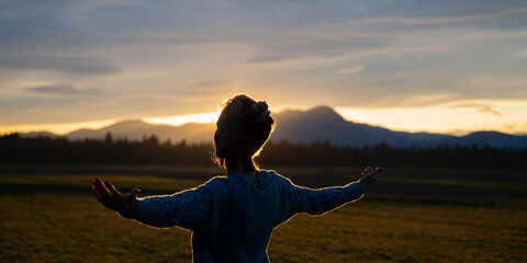 Young woman meditating in nature at sunset - obrazy, fototapety, plakaty