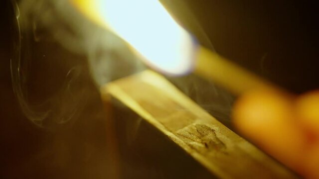 Close up of lighting a match isolated on black background shot in 4k super slow motion