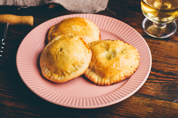 Baked Hand Pies with Chives and Mushrooms on Plate with Glass of Wine