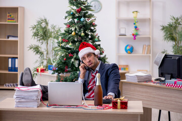 Obraz na płótnie Canvas Young male employee celebrating new year in the office