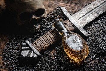Knight sword, magic potion and chain mail on the wooden table close up background.