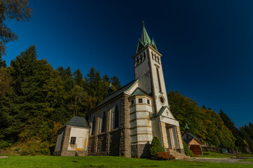 Fototapeta na wymiar Church in Bedrichov village in autumn sunny evening with sunset light