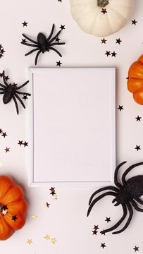 Stop motion animation of mock up flat lay of mini decorative white and orange pumpkin, black spiders and stars from above Halloween and Thanksgiving greeting card holiday concept copy space.