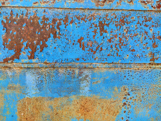 Rusty metal panel with cracked blue paint, corroded grunge metal background