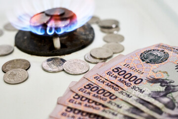 Burning gas stove burner and Uzbek money - sum banknotes. Pay for natural gas, bill, tariff....