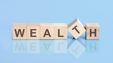 wealth sign made of blocks on a table with a reflective surface, blue background