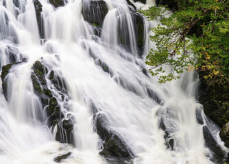 Fototapeta na wymiar long exposure of white water cascading over the magnificent Rhaeadr Ewynnol Swallow Falls Waterfall, Betws-y-coed, Snowdonia National Park, Wales UK
