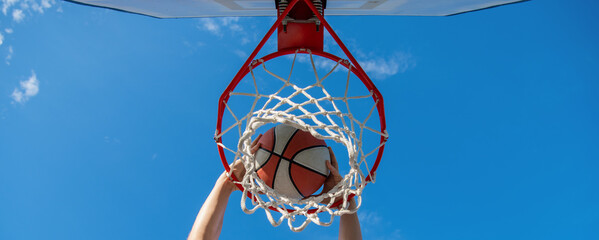 basketball ball dunk through net ring with hands, winning