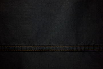 the texture of denim is gray with a side double seam. thread stitches on the background of denim textiles. place to copy. Abstract background and texture for design.