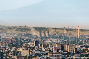 The residential area of Yerevan is located very close to the industrial zone with many pipes and factories that emit harmful chemicals into the air