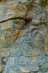 Granite rocks in sunlight. Large sheer granite rock. Hard rock on a sunny day