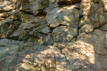 Granite rocks in sunlight. Large sheer granite rock. Hard rock on a sunny day