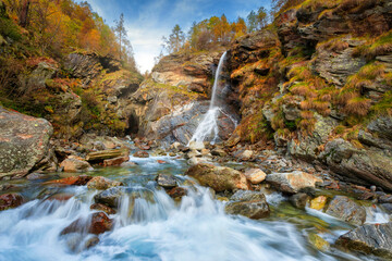 Naklejka na ściany i meble Beautiful autumn landscape with yellow trees and waterfall