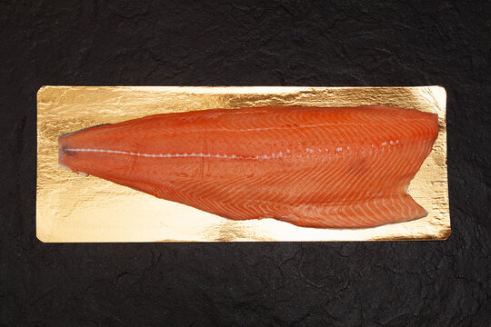 Thawed Salmon Or Sockeye Salmon Fillet On A Dark Textured Stone Background