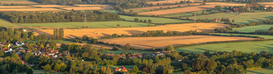 Beautiful foggy morning landscape image looking across fields on the South Downs National Park in rolling English contryside during late Summer