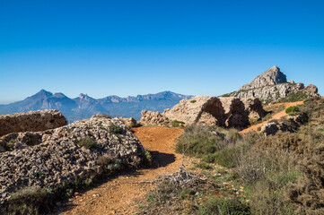 Fototapeta na wymiar scenic ruins of an ancient fortress in the beautiful mediterranean mountain landscape Fort de Bernia and Puig Campana