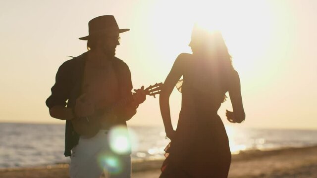 Couple in Love Playing Guitar and Dancing on the Beach