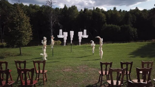 outdoor chandelier decor with green grass and forest backdrop for wedding reception