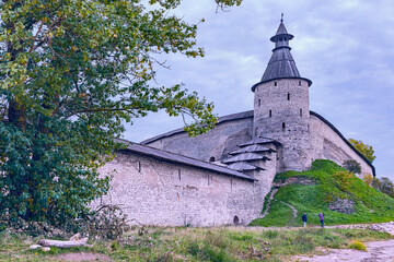 fragment of an old fortress wall with a corner watchtower in the ancient Russian city of Pskov - obrazy, fototapety, plakaty