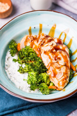 Chicken fillet with sauce greens and white rice in a blue plate. Beautiful food serving