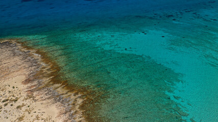 Aerial drone photo of tropical exotic paradise bay with deep turquoise sea and caves forming a blue lagoon visited by luxury yachts and sail boats