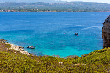 People swimming in the clear blue waters of Proti Island, near Marathopoli, Messinia at Peloponnese.