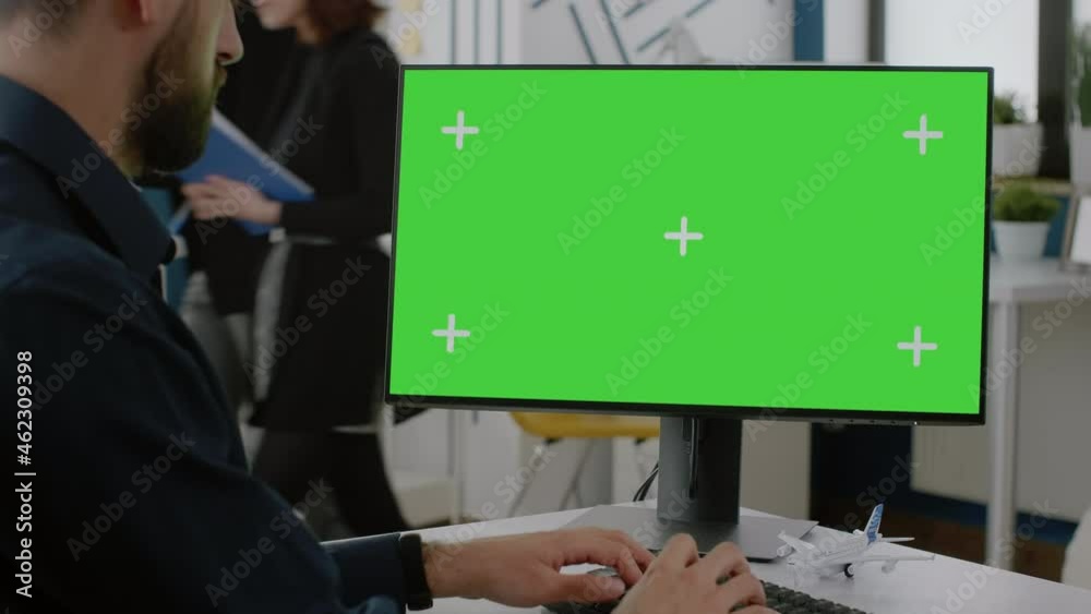 Poster close up of man typing on keyboard with green screen on monitor. business entrepreneur using compute