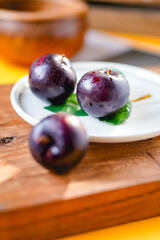Fresh black plums on cutting board