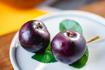 Fresh black plums on cutting board