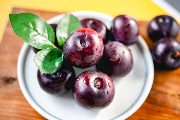 Fresh black plums on cutting board