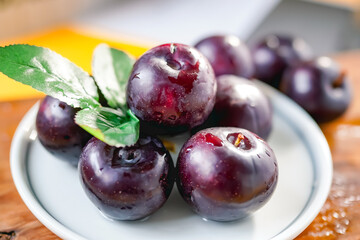Fresh black plums on cutting board