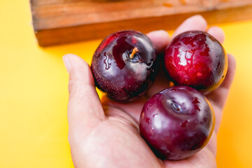Fresh black plums on cutting board