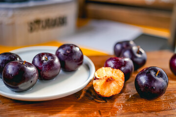 Fresh black plums on cutting board